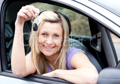 Happy young driver holding a key after bying a new car