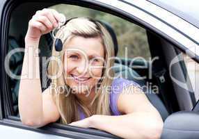 Happy young driver holding a key after bying a new car