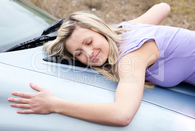 Cheerful female driver huging her new car