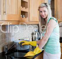 Smiling young woman cleaning in a kitchen