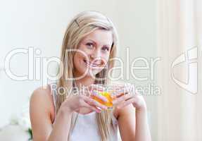 Portrait of a cheerful woman drinking an orange juice