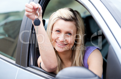 Attractive young driver holding a key after bying a new car