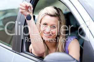 Attractive young driver holding a key after bying a new car