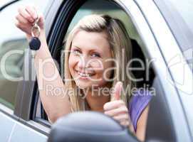 Lively female driver showing a key after bying a new car