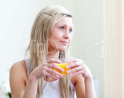 Portrait of a relaxed young woman drinking an orange juice