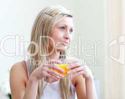 Portrait of a relaxed young woman drinking an orange juice