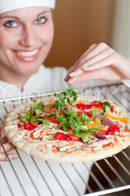 Bright female chef cooking a pizza