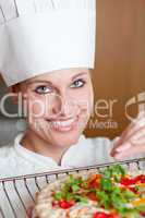 Radiant female chef cooking a pizza