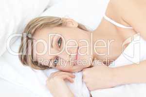 Delighted relaxed woman lying on her bed