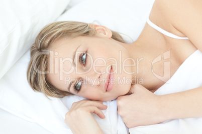Smiling relaxed woman lying on her bed