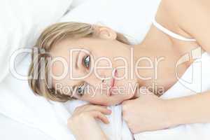 Smiling relaxed woman lying on her bed