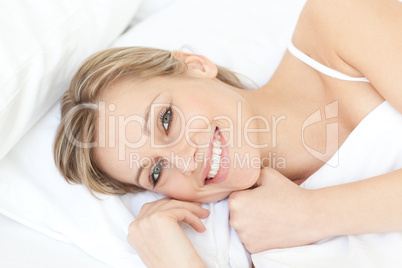 Bright relaxed woman lying on her bed