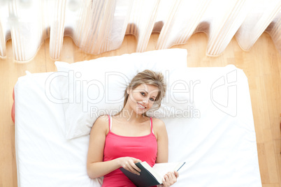 Radiant young woman reading a book