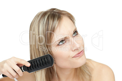 Annoyed woman bruishing her hair