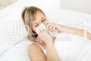 Sick woman blowing lying on her bed