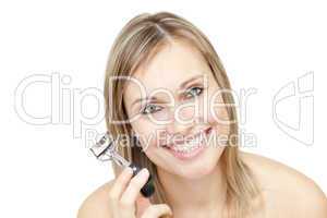 Cheerful woman holding an eyelash curler