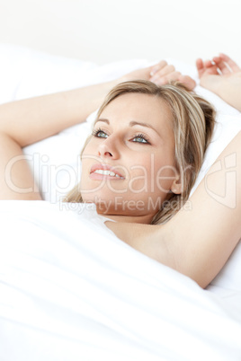 Beautiful young woman resting lying on a bed