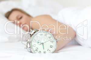 Young woman holding an alarm clock