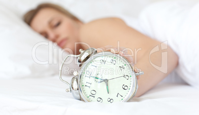 Blond woman holding an alarm clock