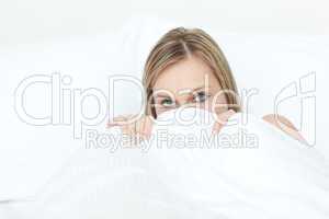 Beautiful woman hiding in her bed