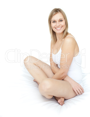 Delighted smiling woman sitting on a bed