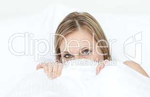 Close-up of a woman hiding in her bed