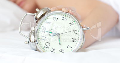 Close-up of a woman holding an alarm clock