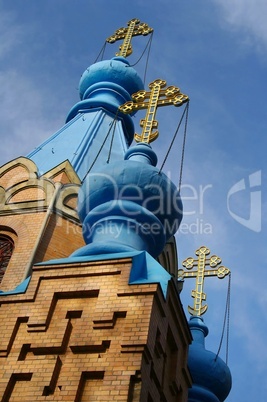 Kirchturm mit Zwiebeldach und goldenem Kreuz