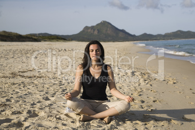 Frau macht Yoga am Strand