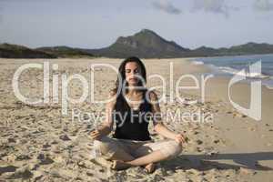 Frau macht Yoga am Strand