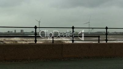 Stormy waves on the river with wind turbines in the background 2
