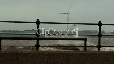 Stormy waves on the river with wind turbines in the background 3