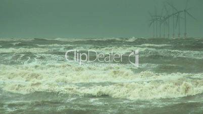 Stormy waves on the river with wind turbines in the background 7