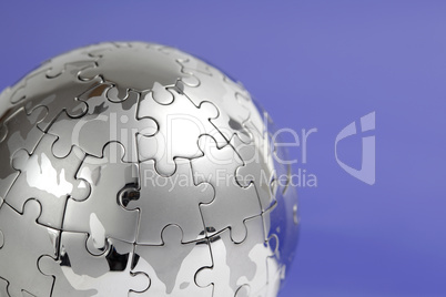 Puzzle- Globus, close- up vor blauem Hintergrund