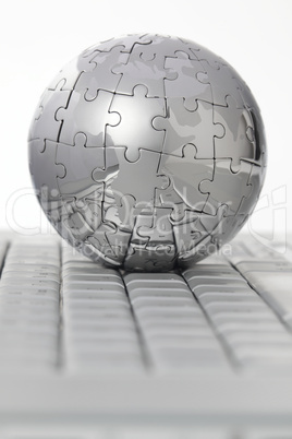 Puzzle- Globus auf Tastatur