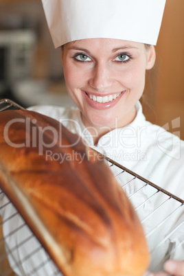 Smiling female chef baking bread