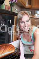 Cheerful blond woman baking bread