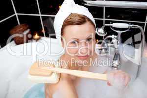 Smiling caucasian woman taking in a bubble bath
