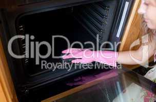 Close-up of a woman cleaning the oven