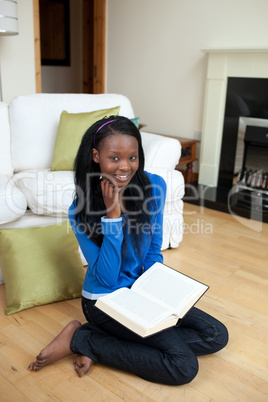Chrming woman reading a book sitting on the floor