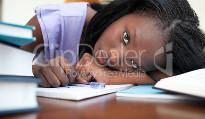 Exhausted Afro-American woman resting while studying