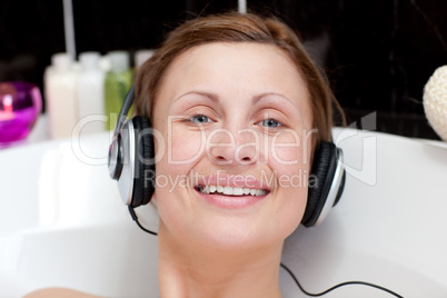 Cheerful woman using headphones in a bubble bath