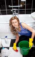 Unhappy woman cleaning bathroom's floor