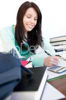 Cheerful teen girl studying on a desk