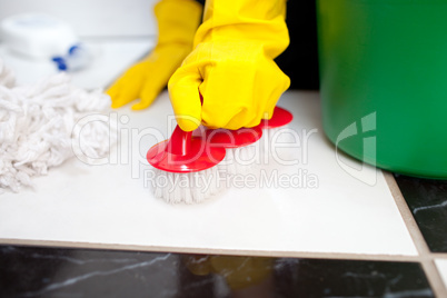 Woman cleaning a bathroom's floor