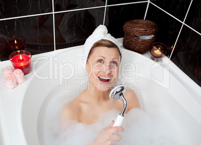 Cheerful young woman singing in a bubble bath