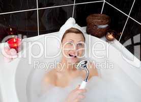Cheerful young woman singing in a bubble bath
