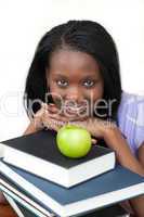 Young student holding books smiling at the camera