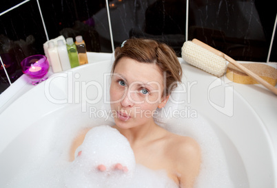 Attractive woman playing in a bubble bath