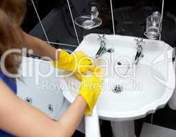 Woman cleaning a bathroom's sink